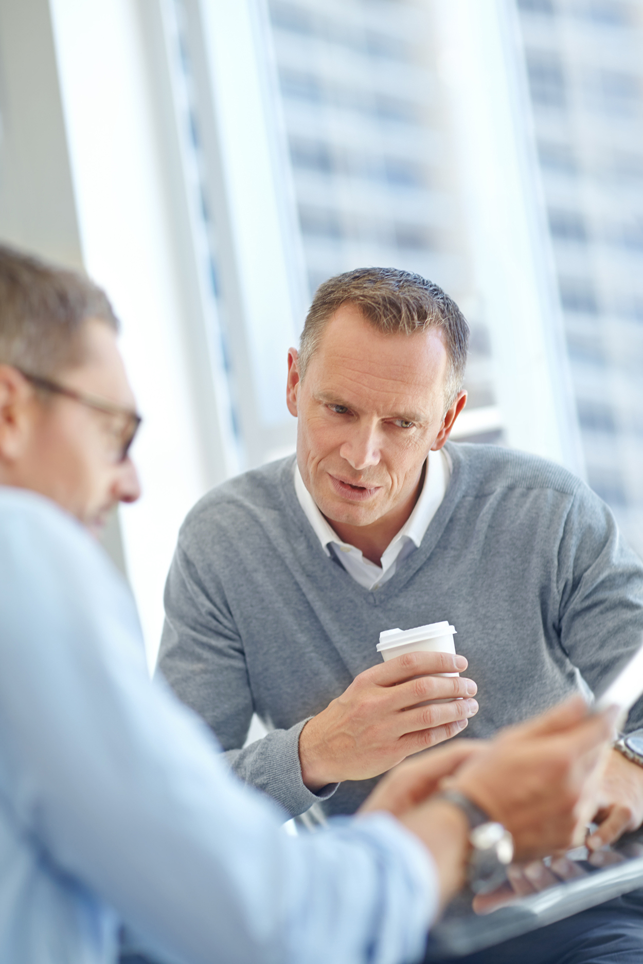 Two men in finance discussing business in office environment. Sample photo for web design sample purposes. Web design sample template. Custom web design.